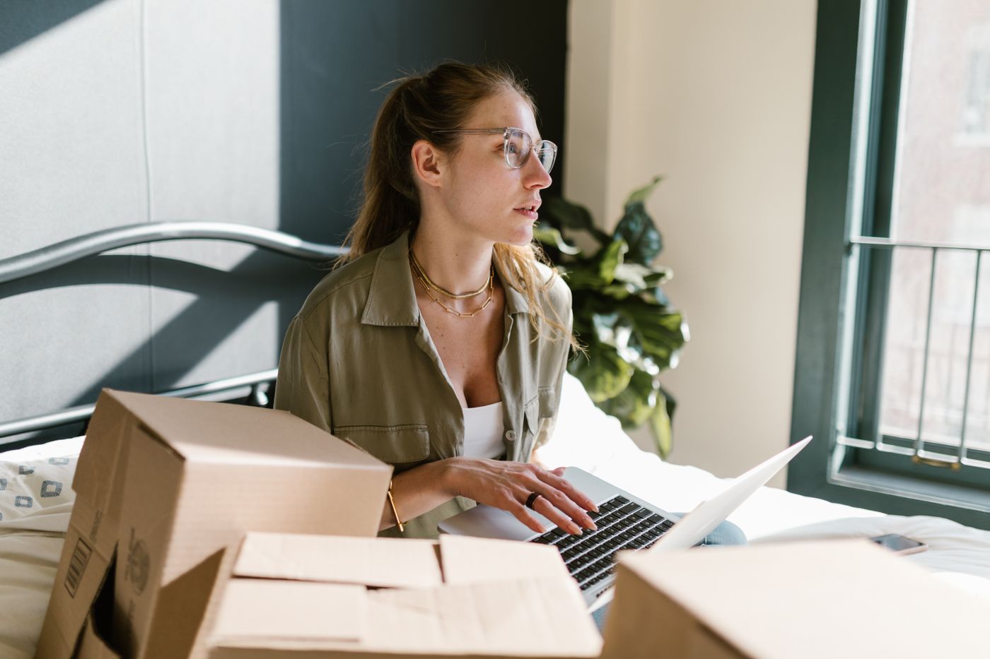 A packer working at a laptop among parcels