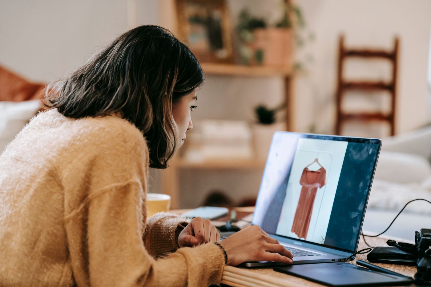 A customer browsing clothes in an online store at a laptop